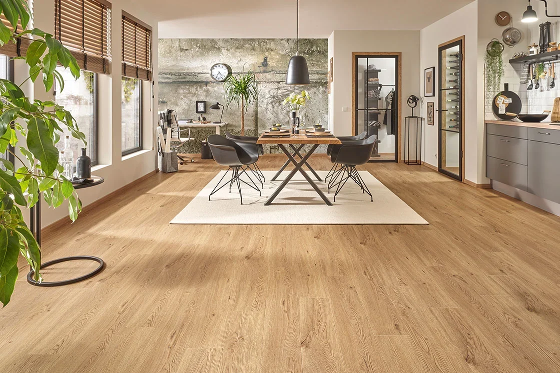 Heller Designboden in Holzoptik verbindet Küche und Essplatz mit großen Fenstern. Lernen Sie JOKA-Designböden kennen und vergleichen Sie passende Klick- oder Klebevarianten. Heller Designboden in Holzoptik verbindet Küche und Essplatz mit großen Fenstern